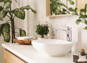 biała łazienka z dużą ilością roślin zielonych